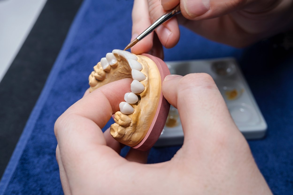 Dental technician or dentist working with tooth dentures model in his laboratory. Prosthetic dentistry technician working in his office